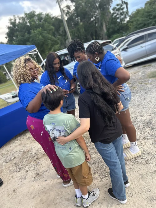 Experience Foundation volunteers gathered with children in a community care circle
