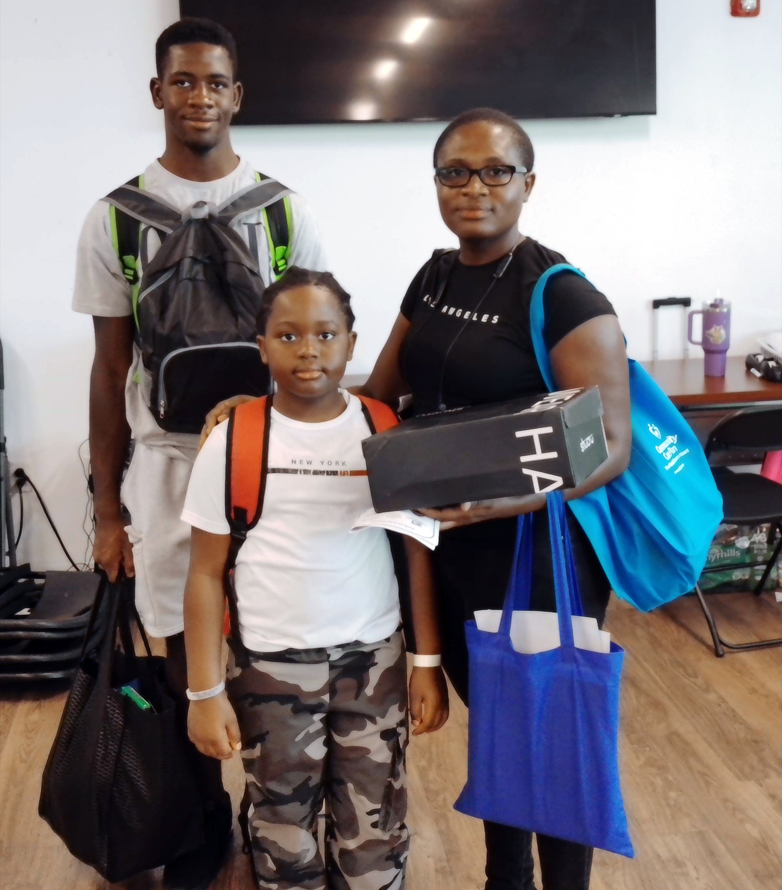 A family receiving backpacks and school supplies from the Foundation