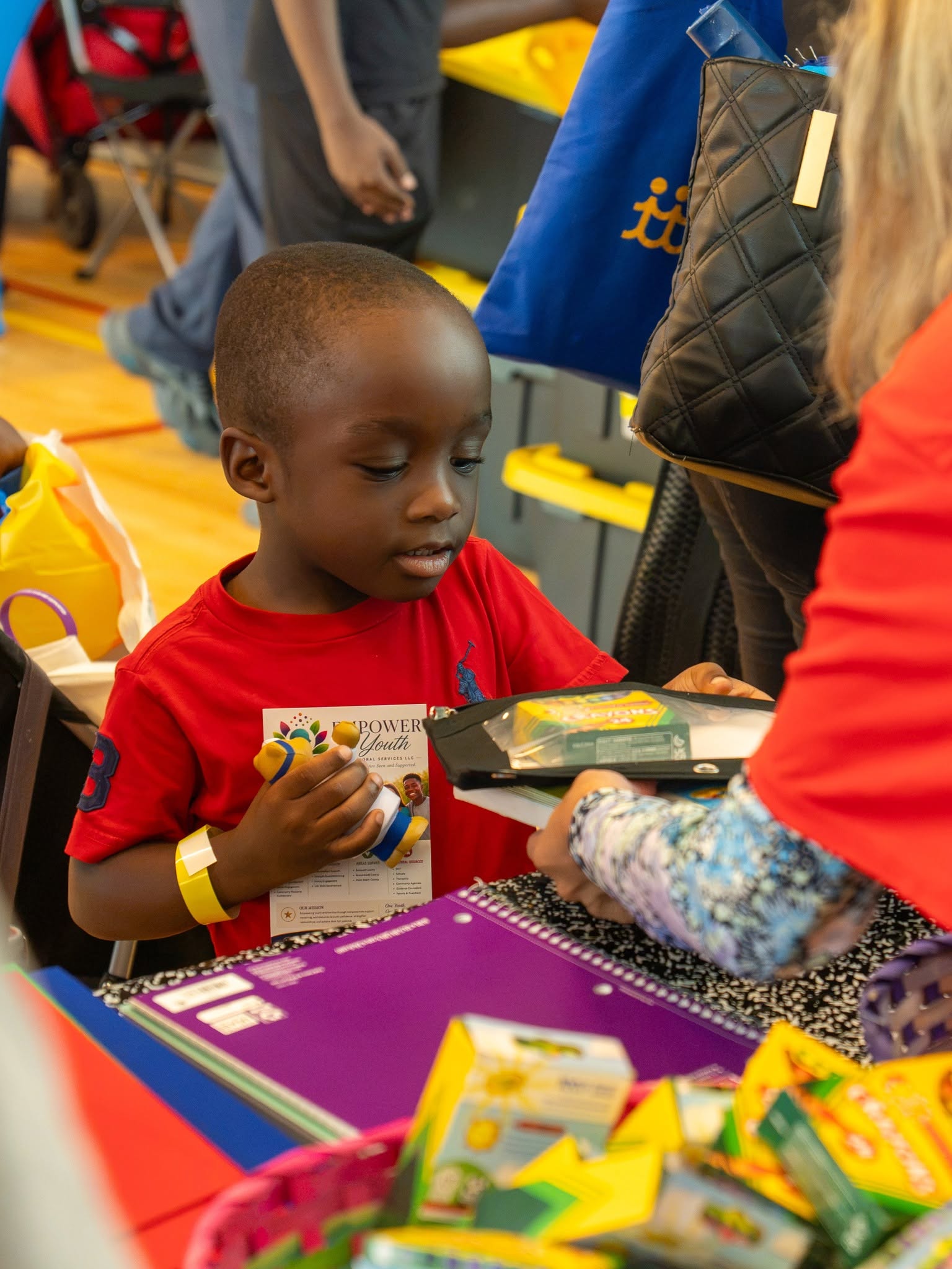 A child receiving school supplies at a community event